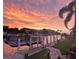 A waterfront view at sunset, showcasing a boat lift, and lush landscaping at 2160 Palm Tree Dr, Punta Gorda, FL 33950