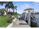 Pristine concrete dock showcasing a boat, lush green grass, and a tranquil atmosphere for peaceful waterfront living at 2160 Palm Tree Dr, Punta Gorda, FL 33950