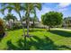 Lush front yard with palm trees leading to a well-maintained, one-story home with a tile roof at 2160 Palm Tree Dr, Punta Gorda, FL 33950