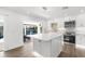 Stylish kitchen with white cabinets, stainless steel appliances, and an island overlooking the pool area at 2160 Palm Tree Dr, Punta Gorda, FL 33950