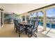 The lanai features a table, chairs, and wet bar with pool and canal views at 2160 Palm Tree Dr, Punta Gorda, FL 33950