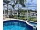 Screened-in pool and spa overlooking a serene waterfront canal view, ideal for relaxation at 2160 Palm Tree Dr, Punta Gorda, FL 33950