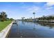 Scenic waterfront view features a canal lined with lush greenery, palm trees, and lovely homes on a sunny day at 2160 Palm Tree Dr, Punta Gorda, FL 33950