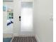 Hallway leading to a bedroom, featuring a patterned rug and partially frosted glass door at 2255 N Beach Rd # 13, Englewood, FL 34223