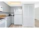 Bright kitchen featuring gray cabinetry, white appliances, and a utility closet at 2255 N Beach Rd # 13, Englewood, FL 34223