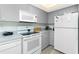 Cozy kitchen with gray cabinets, white appliances, and laminate countertops at 2255 N Beach Rd # 13, Englewood, FL 34223