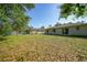 Large backyard showing the back of the property and trees at 2495 De Garmo St, North Port, FL 34291