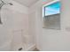 Bathroom shower features an updated shower head and a bright window at 2495 De Garmo St, North Port, FL 34291