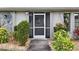 Inviting front door entrance featuring a security screen door, well maintained door, and mature landscaping at 3 Bunker Pl, Rotonda West, FL 33947