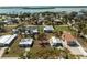 An aerial view of a charming single-story home with a white roof and a well-manicured lawn near the water at 3210 Holly Ave, Englewood, FL 34224