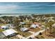 An aerial view of the home in a coastal community near the water with lush landscaping and mature trees at 3210 Holly Ave, Englewood, FL 34224