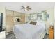 Bedroom featuring a bed with white comforter, ceiling fan, and windows at 3210 Holly Ave, Englewood, FL 34224