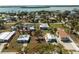 Aerial view of home close to waterfront, surrounded by lush trees and other well-maintained properties at 3220 Holly Ave, Englewood, FL 34224
