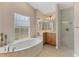 Bright bathroom features a soaking tub with jets, vanity, and a glass-enclosed shower at 4050 Rock Creek Dr, Port Charlotte, FL 33948