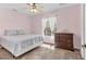 Cozy bedroom with plush carpeting, a ceiling fan, and a dresser near the window at 4050 Rock Creek Dr, Port Charlotte, FL 33948