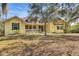 Charming yellow home with a welcoming front porch and lush green lawn at 4050 Rock Creek Dr, Port Charlotte, FL 33948