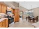 Well-lit kitchen with wooden cabinets, stainless steel appliances, and an adjacent dining area at 4050 Rock Creek Dr, Port Charlotte, FL 33948