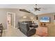 Spacious living room featuring vaulted ceilings, a ceiling fan, and a comfortable leather sofa set at 4050 Rock Creek Dr, Port Charlotte, FL 33948