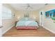 Bright bedroom features a ceiling fan, wood floors, and an ensuite bathroom at 414 Circlewood Dr # H2, Venice, FL 34293