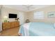 Comfortable bedroom with light wood floors, a large dresser, and a ceiling fan at 414 Circlewood Dr # H2, Venice, FL 34293