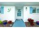 Welcoming home entrance featuring vibrant landscaping, blue shutters, and a decorative wreath for added charm at 414 Circlewood Dr # H2, Venice, FL 34293