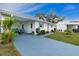 Charming exterior showcasing lush landscaping, blue accents, and covered parking for convenience and curb appeal at 414 Circlewood Dr # H2, Venice, FL 34293