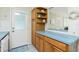 Classic kitchen with wood cabinetry, open shelving, and a view into the adjacent living space at 414 Circlewood Dr # H2, Venice, FL 34293