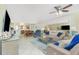 Spacious living room with a mirrored wall, ceiling fan, and an open flow to the dining area at 414 Circlewood Dr # H2, Venice, FL 34293