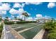 Outdoor shuffleboard courts with benches in a sunny community setting under a bright blue sky with white puffy clouds at 414 Circlewood Dr # H2, Venice, FL 34293