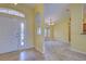 Foyer with beige tile flooring, a front door with transom window, and an arched opening to the living room at 4966 Sunnyvale Rd, North Port, FL 34288