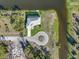 This is an aerial view of the home, with a circular driveway, surrounding canal, and private dock at 5 Reef Ct, Placida, FL 33946