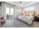 Bright bedroom with neutral walls, modern patterned rug, sliding glass doors to a patio, and water views at 5 Reef Ct, Placida, FL 33946