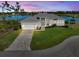 Beautifully landscaped single-story home with a two-car garage, brick driveway, and serene lake view at 5 Reef Ct, Placida, FL 33946