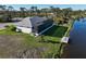 A house's exterior features a screened-in porch, gray roof, white exterior, and wooden dock on the canal at 5 Reef Ct, Placida, FL 33946