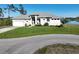 Inviting one-story home featuring a two-car garage, fresh landscaping, and a picturesque waterfront backdrop at 5 Reef Ct, Placida, FL 33946