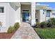 Inviting front entrance featuring a paver walkway, lush landscaping, and a modern glass front door at 5 Reef Ct, Placida, FL 33946