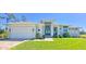 A well-manicured lawn and landscaping highlight this contemporary home with a two-car garage at 5 Reef Ct, Placida, FL 33946