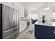 Modern kitchen featuring stainless steel appliances, white cabinets, a large island, and elegant pendant lighting at 5 Reef Ct, Placida, FL 33946