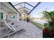 This screened lanai includes lounge chairs, a television, and a scenic view of the water at 5 Reef Ct, Placida, FL 33946