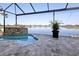 Backyard pool and spa featuring a rock waterfall and beautiful lake view at 5 Reef Ct, Placida, FL 33946