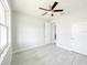 Bedroom with grey wood floors, a ceiling fan, window, and doors at 5213 Willow Lake Ct, Sarasota, FL 34233