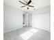 Light-filled bedroom with a ceiling fan, closet with bi-fold doors, and bright gray flooring at 5213 Willow Lake Ct, Sarasota, FL 34233