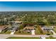 Aerial view showcasing the home nestled on a large lot with lush greenery and mature trees at 5441 Farley St, Port Charlotte, FL 33981