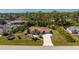 An aerial view of the home showcasing the property's manicured lawn, palm trees, and long driveway at 5441 Farley St, Port Charlotte, FL 33981