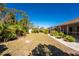 Expansive backyard with tropical foliage, a screened lanai, and meticulous rock border at 5441 Farley St, Port Charlotte, FL 33981