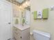 Bathroom features a white vanity, toilet, and mirror with decorative wallpaper at 5441 Farley St, Port Charlotte, FL 33981