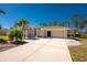 Well-maintained home featuring a spacious driveway and attached two-car garage, enhanced by palm trees at 5441 Farley St, Port Charlotte, FL 33981