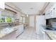 Cozy kitchen with granite countertops, white appliances, and tile flooring for easy maintenance at 5441 Farley St, Port Charlotte, FL 33981