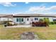 Charming backyard with a patio area, seating, and lush landscaping under a bright sky at 613 Chestnut Ln, Englewood, FL 34223