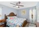 Inviting bedroom with a ceiling fan, patterned bedding, and a window with sheer curtains at 613 Chestnut Ln, Englewood, FL 34223